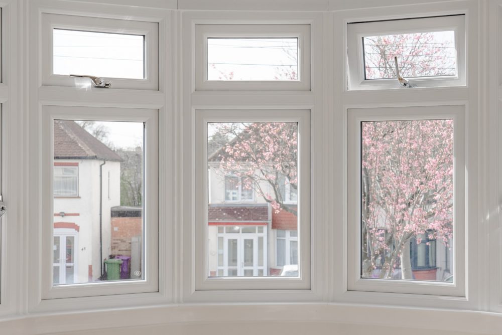 The inside of a set of white casement windows.